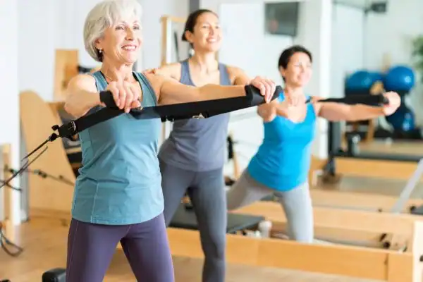 Toning Arms After 60: Empowering Womens Fitness Through Effective Weight Training 2 older woman doing weight training Calne and resistance in the gym to tone upper arms